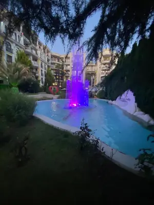a fountain in the middle of a swimming pool at night at Schöne Ferienwohnung im Harmony Suites Monte Carlo in Sunny Beach