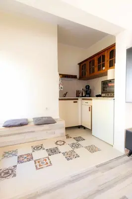 a kitchen with white cabinets and a bed in a room at Mila 6 in Burgas City