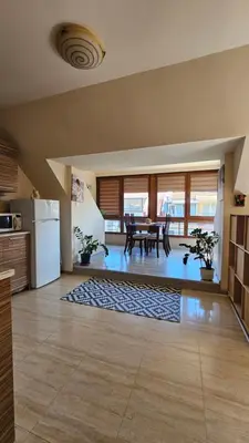 a large kitchen with a table and a refrigerator at Уютно студио до центъра на Бургас in Burgas City
