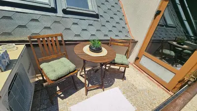 a table and chairs on a balcony with a potted plant at Уютно студио до центъра на Бургас in Burgas City