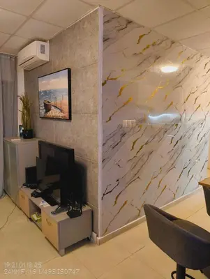a living room with a marble wall with a television at Tarsis nova slunchev Briak Apartament 08 A in Sunny Beach