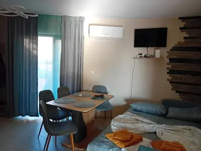 a room with two beds and a table and a bed at Тристаен апартамент Еуфория, Свети Влас in Sveti Vlas