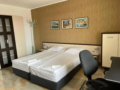 a bedroom with a large bed and a chair at Apart di Landi in Ravda