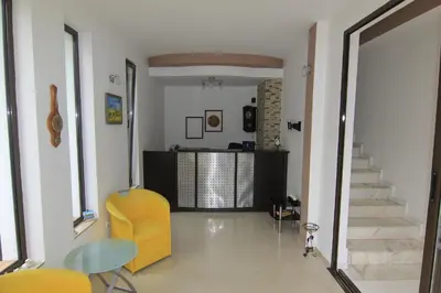 a living room with a yellow chair and stairs at Apart di Landi in Ravda