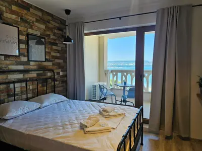 a bedroom with a bed with a brick wall at Comfy Flat Sea View & Strong Wi-Fi in Varna City