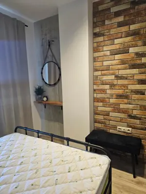 a bedroom with a bed and a brick wall at Comfy Flat Sea View & Strong Wi-Fi in Varna City