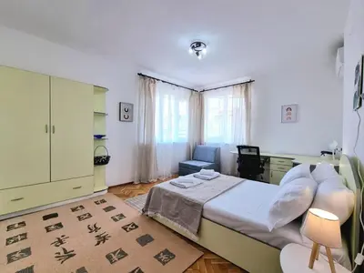 a bedroom with a bed and a chair in it at Central - 3BD Holiday Apartment for Family & Friends in Burgas City