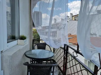 a table and chairs on a balcony with a window at Central - 3BD Holiday Apartment for Family & Friends in Burgas City