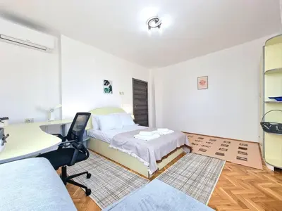 a bedroom with a bed and a desk and a desk at Central - 3BD Holiday Apartment for Family & Friends in Burgas City