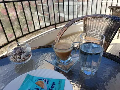a table with two glasses and a glass of water on a balcony at Aura Blu Studio in Sunny Beach