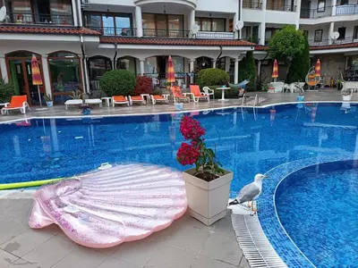 a large swimming pool with a bird standing next to it at Aura Blu Studio in Sunny Beach
