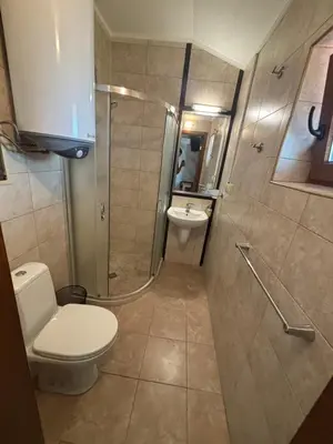 a bathroom with a toilet and a shower and a sink at Стая за гости - 1 in Sozopol