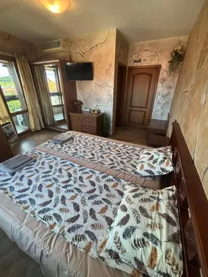 a large bed in a room with a stone wall at Стая за гости - 1 in Sozopol