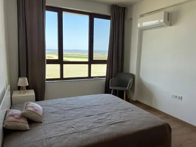a bedroom with a bed and a large window at Deluxe Apartment with Sea View Vineyard Spa Resort Aheloy in Aheloy