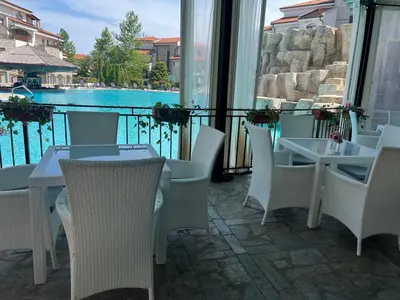 a patio with tables and chairs and a view of the water at Deluxe Apartment with Sea View Vineyard Spa Resort Aheloy in Aheloy