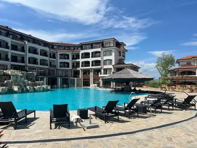 a large hotel with a swimming pool with lounge chairs at Deluxe Apartment with Sea View Vineyard Spa Resort Aheloy in Aheloy