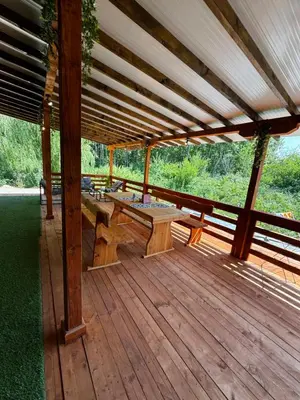 a wooden deck with benches and tables on it at Вила Бонита плаж Градина in Burgas City