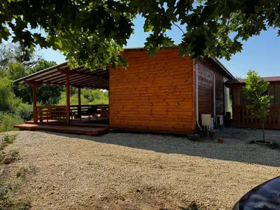 a pavilion with a picnic table in front of a building at Вила Бонита плаж Градина in Burgas City