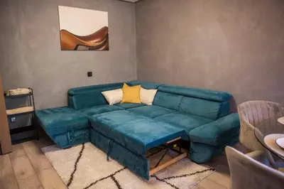 a living room with a blue couch in a room at KIM Centre in Burgas City