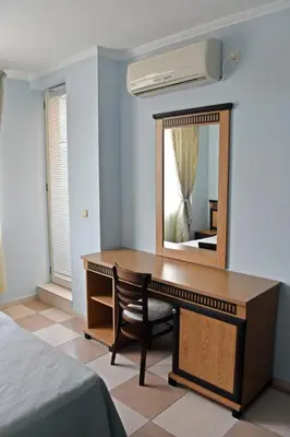 a dressing table with a mirror and a bed at Anvers Apartments in Sozopol