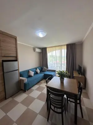 a living room with a blue couch and a table at Anvers Apartments in Sozopol