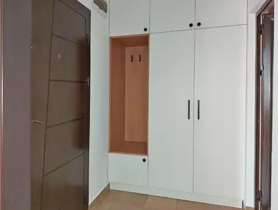 a closet with white cabinets and a wooden door at Masada in Burgas City