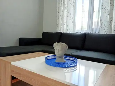 a living room with a couch and a vase on a table at Masada in Burgas City