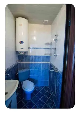 a blue tiled bathroom with a toilet and a sink at Guesthouse Christina in Varna City