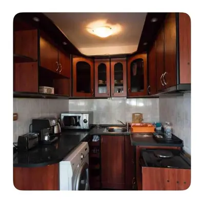 a kitchen with wooden cabinets and a counter top at Guesthouse Christina in Varna City