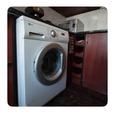 a washing machine in a kitchen with a counter at Guesthouse Christina in Varna City