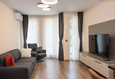 a living room with a couch and a flat screen tv at Exclusive Central Varna Apartment - 2 Beds and Parking by Flat Mаnаger in Varna City