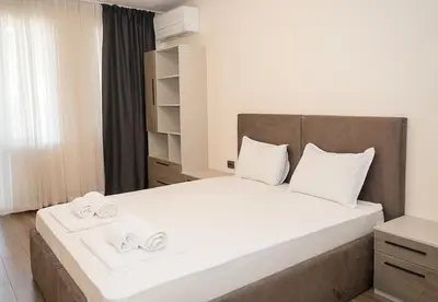 a bedroom with a large bed with two towels on it at Exclusive Central Varna Apartment - 2 Beds and Parking by Flat Mаnаger in Varna City