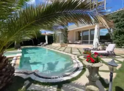 a swimming pool in a backyard with a palm tree at Villa Dolce Vita in Sunny Beach
