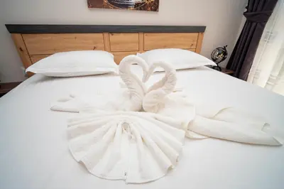 two swans wrapped in white towels on a bed at Marea Garden, Ravda - 1BD Apartment with Pool by Flat Mаnager in Ravda