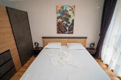 a bedroom with a white bed with a painting on the wall at Marea Garden, Ravda - 1BD Apartment with Pool by Flat Mаnager in Ravda