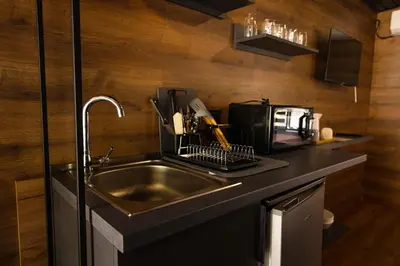 a kitchen with a sink and a microwave at Къмпинг- бунгала Албатрос in Varna City