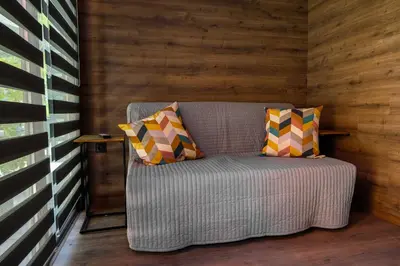 a couch sitting in a room with wooden walls at Къмпинг- бунгала Албатрос in Varna City