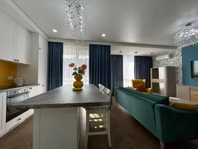 a kitchen and living room with a table and a couch at Bayview Family 2 in Burgas City
