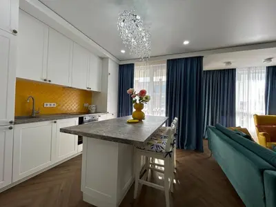 a kitchen with a table with a vase of flowers on it at Bayview Family 2 in Burgas City