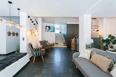 a living room with a couch and chairs and stairs at Hotel Sozopol 99 in Sozopol
