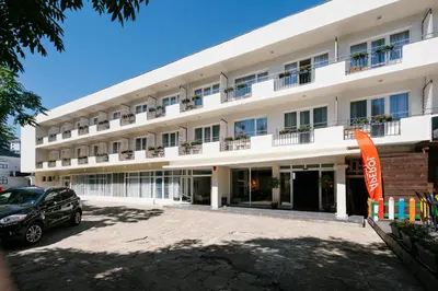 a large white building with a car parked in front at Hotel Sozopol 99 in Sozopol
