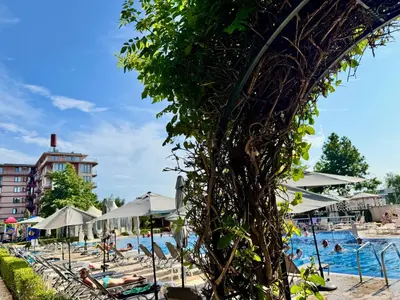 a pool with chairs and umbrellas and people at a resort at Apartment B48 in Tarsis Club Complex in Sunny Beach