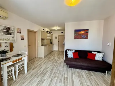 a living room with a couch and a kitchen at Apartment B48 in Tarsis Club Complex in Sunny Beach