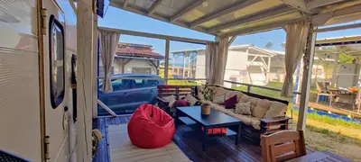 an rv patio with a couch and a table at Яката Каравана in Kiten