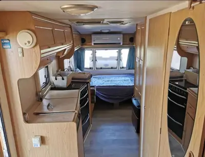 an interior view of a camper van with a bedroom at Яката Каравана in Kiten
