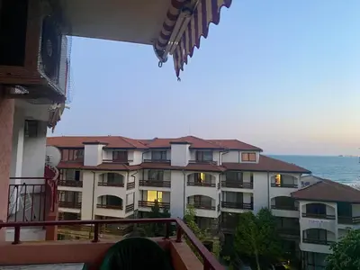 a large apartment building with the ocean in the background at Beachfront Studio with Sea Views in Sveti Vlas