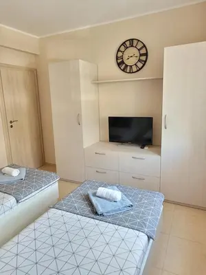 two beds in a room with a tv and a clock at Dolce Vita 1 Ap-6 in Sveti Vlas