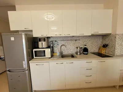a kitchen with white cabinets and a sink and a refrigerator at Dolce Vita 1 Ap-6 in Sveti Vlas