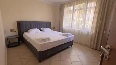 a bedroom with a bed with white sheets and a window at Summer Mood, Forest Feeling in Sozopol in Sozopol