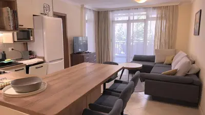 a kitchen and living room with a table and a couch at Summer Mood, Forest Feeling in Sozopol in Sozopol